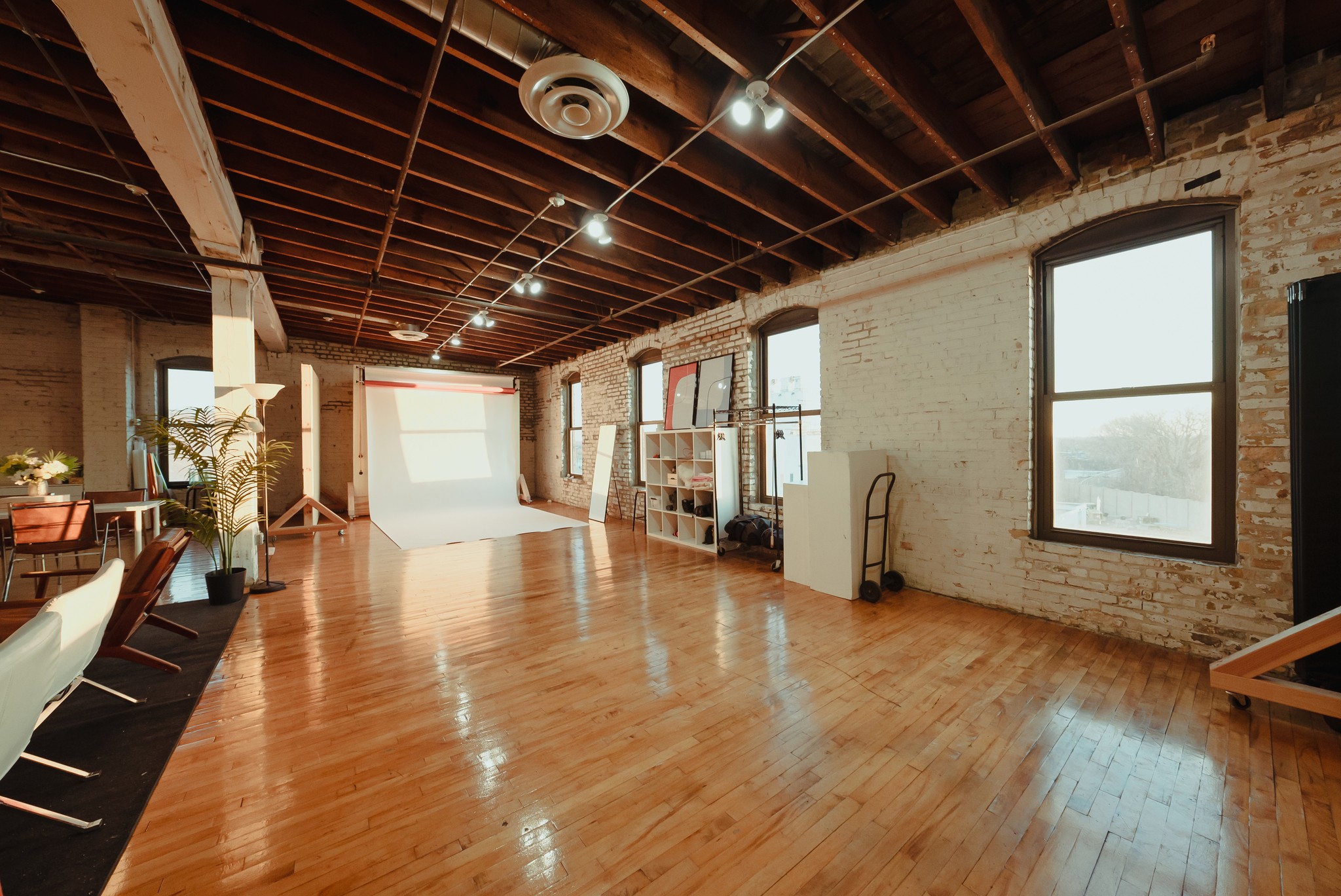 The Bloom Creativ studio, with a white cove, brick wall, and leather couch
