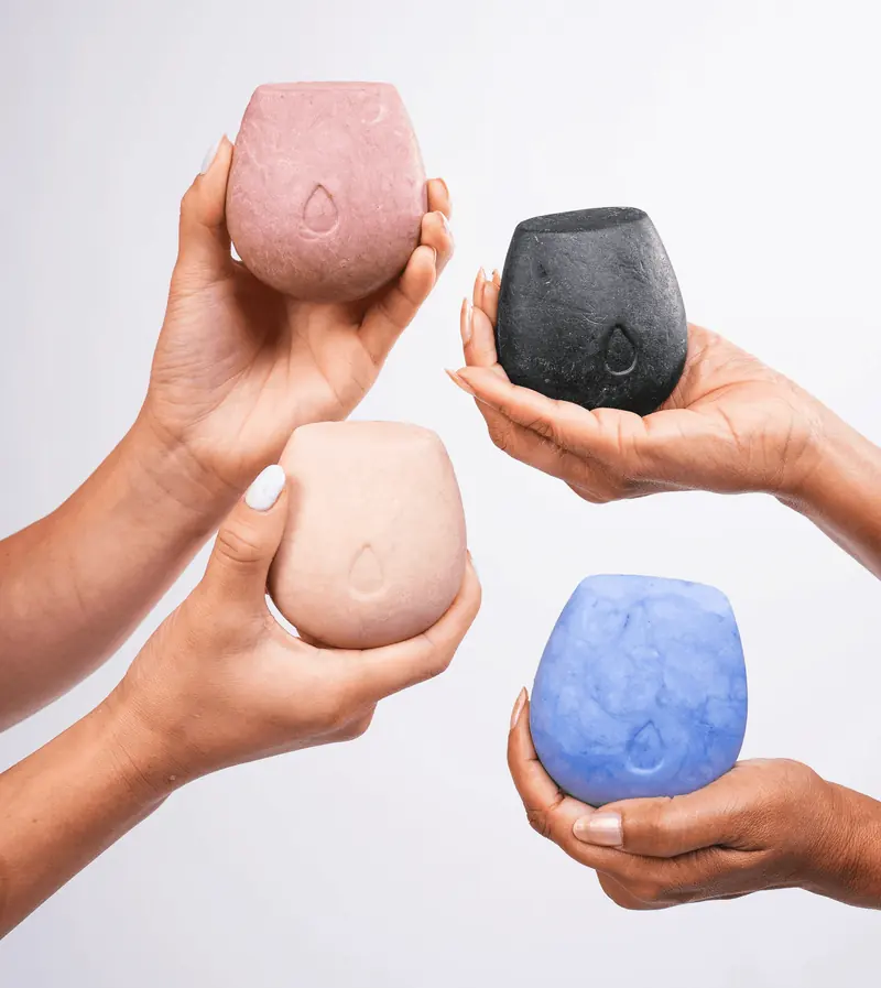 HiBAR shampoo and conditioner bars on a bathroom shelf