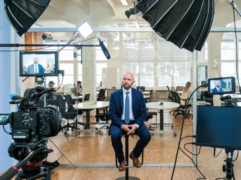 A person presenting to a small group in an office, for corporate videos